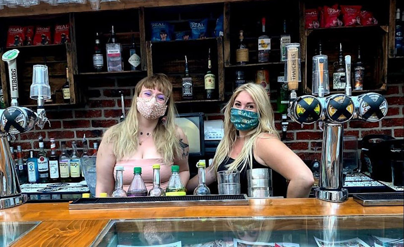 Staff in face masks behind bar at Mr Wolf's